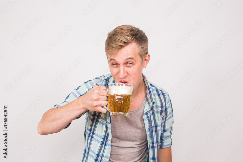 Man drinks beer. Handsome young guy drinking lager pint on white background Man drinks beer. Handsome young guy drinking lager pint on white background