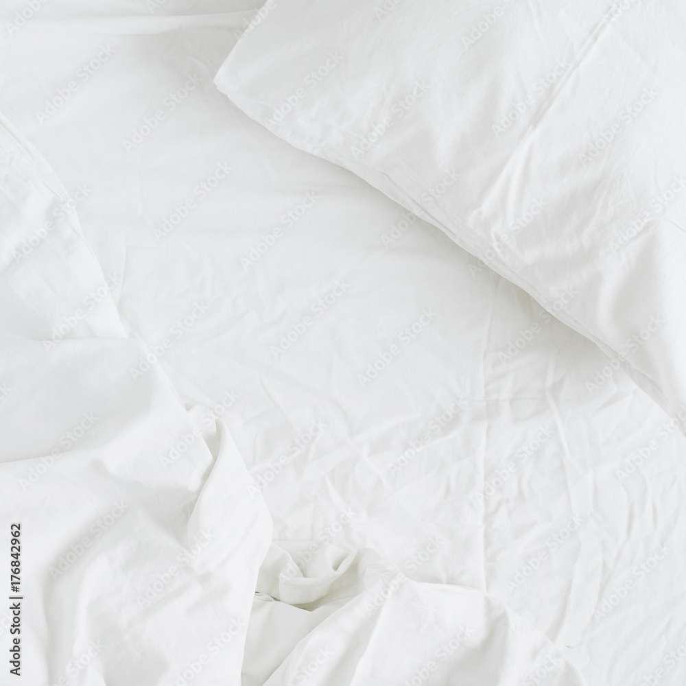 Flat lay of white bed with pillows, blanket and sheet. Top view minimal linen concept. Flat lay of white bed with pillows, blanket and sheet. Top view minimal linen concept.