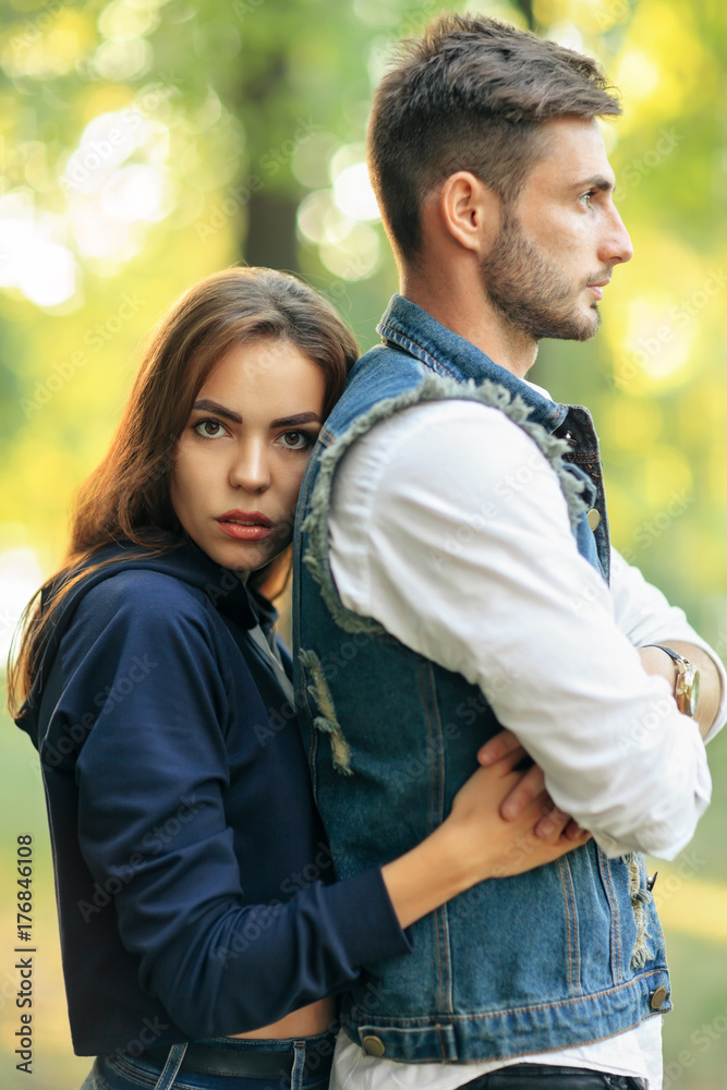 Young beautiful woman embracing her man from back outdoors Young beautiful woman embracing her man from back outdoors