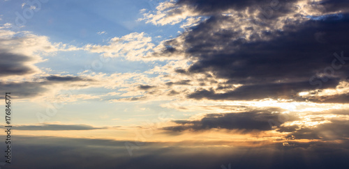 Astonishing view of sunset with dark clouds and golden sunbeams.