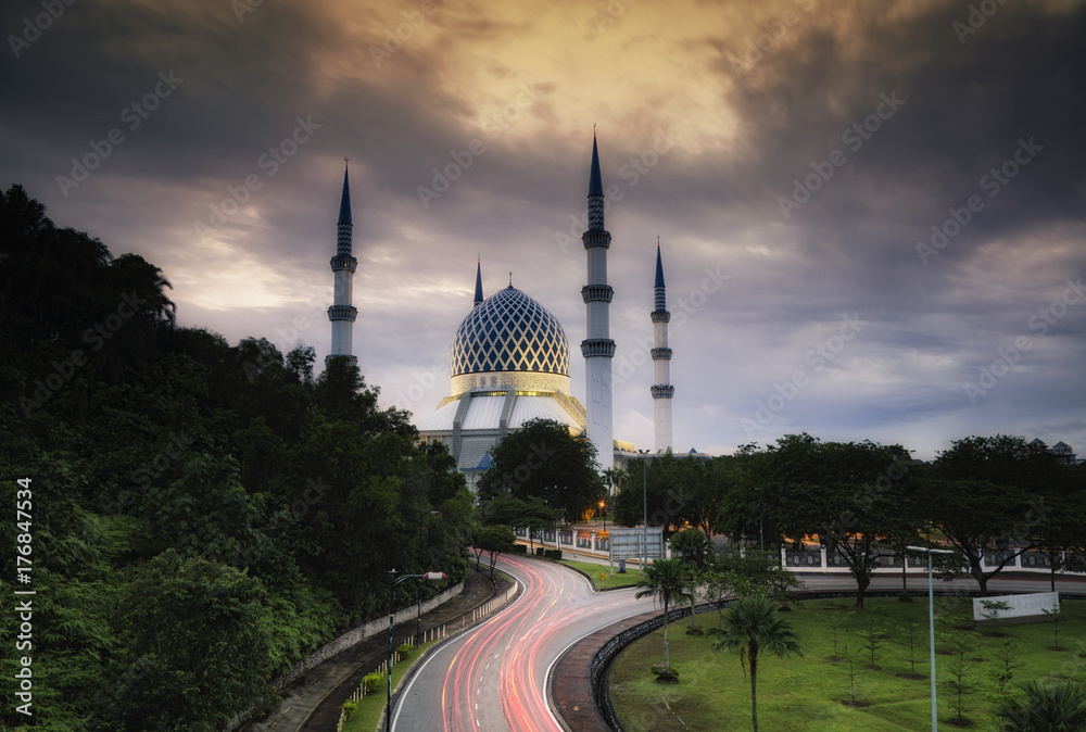 Naklejka premium The beautiful Sultan Salahuddin Abdul Aziz Shah Mosque over stunning sunrise background. soft focus due to long exposure shot.