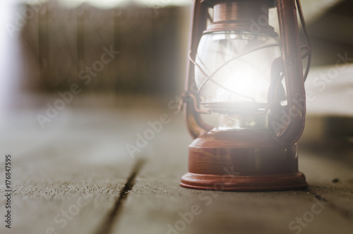 Vintage lantern on wooden floor, copy space to the left for text