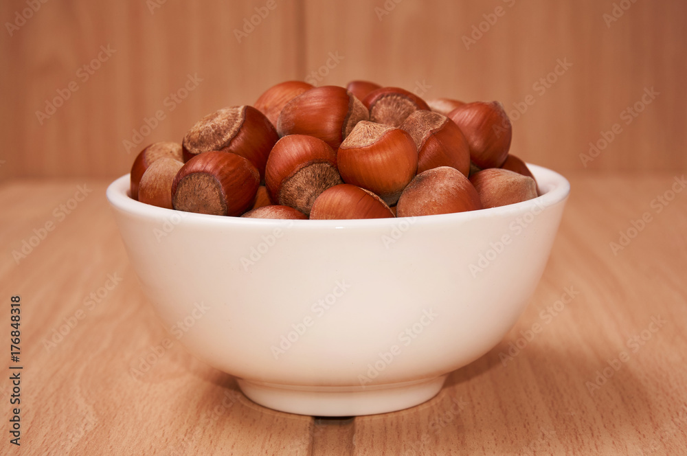 Nuts in a bowl on a wooden background, Brown nuts. Nuts.Side view. Nuts in a bowl on a wooden background, Brown nuts. Nuts.Side view.
