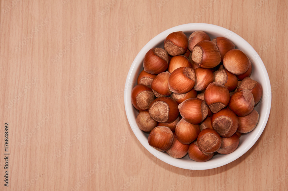 Nuts in a bowl on a wooden background, Brown nuts. Nuts. Top view. Nuts in a bowl on a wooden background, Brown nuts. Nuts. Top view.