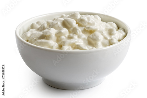 White ceramic bowl of chunky cottage cheese isolated on white.