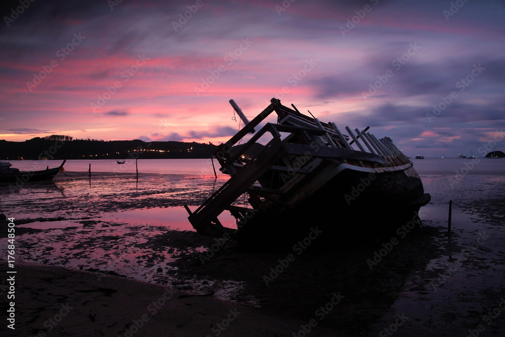 Wreckship on beach with twilight sky at dusk
