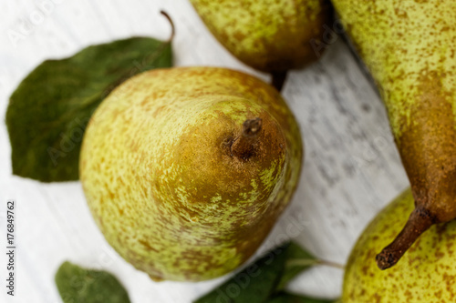 Billede på lærred Closeup of abate fetel pear with leaves on white painted wood from above