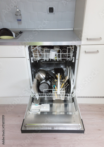 Open dishwasher with clean plates, cups and dishes