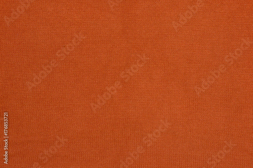 Orange texture of a sweater. Fabric with the texture of a knitted sweater.