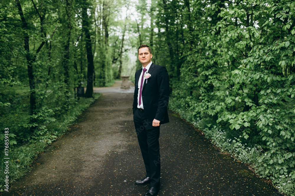 Handsome groom near the old house Handsome groom near the old house