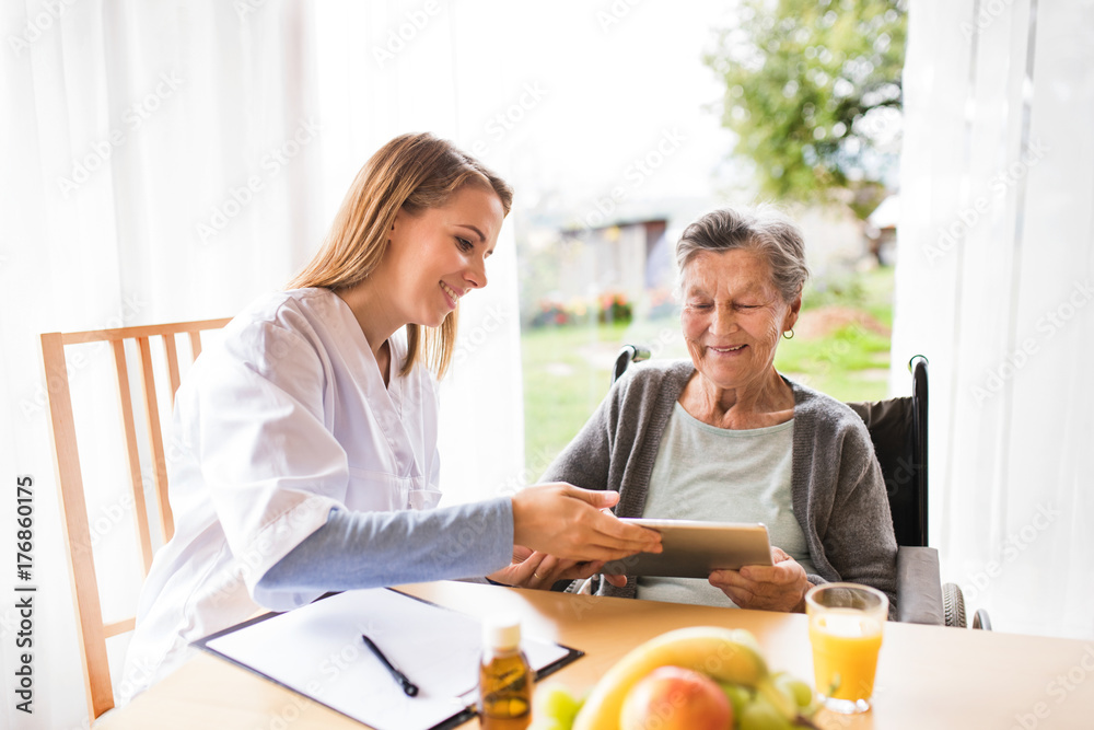 Health visitor and a senior woman with tablet. Health visitor and a senior woman with tablet.