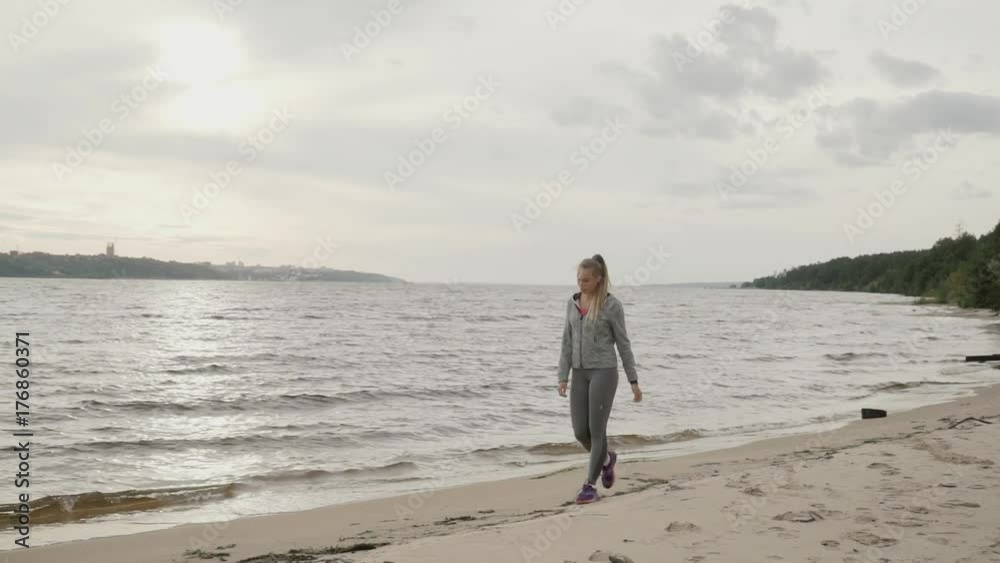 Tired girl goes along the shore after training. Slow motion. Tired girl goes along the shore after training. Slow motion.