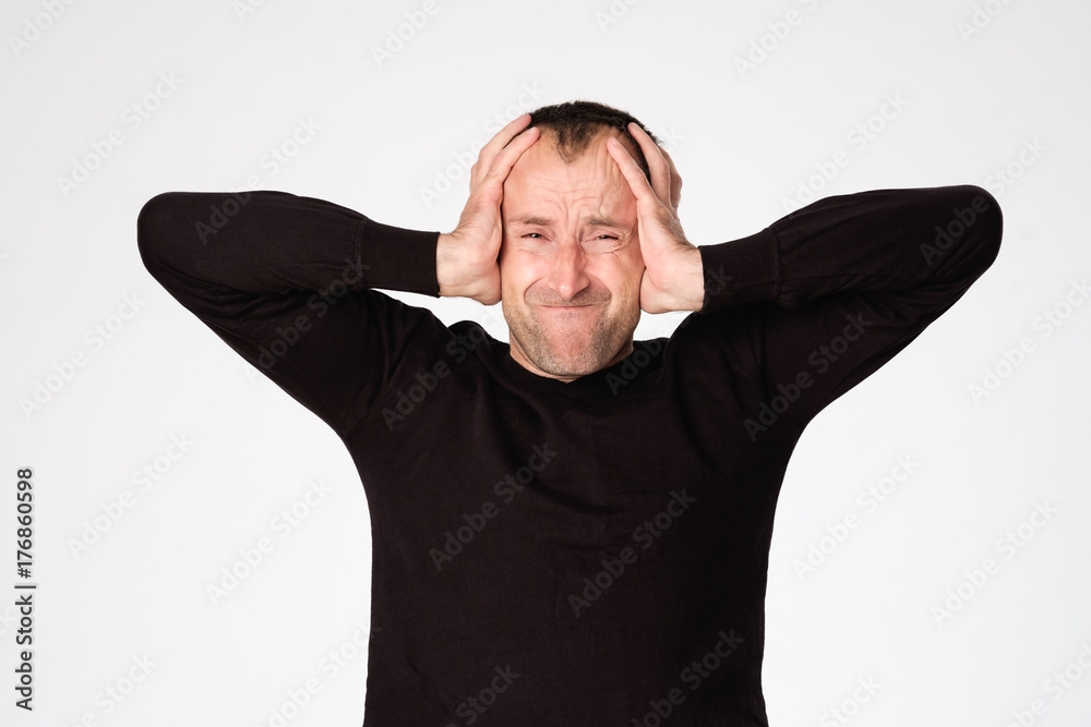 Mature spanish man closing his ears because of headache or migraine Mature spanish man closing his ears because of headache or migraine