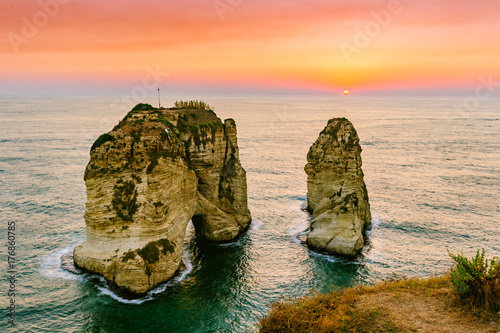 Beautiful sunset on Raouche  Pigeons  Rock. In Beirut  Lebanon.Sun and Stones are reflected in water.dense clouds in the sky.
