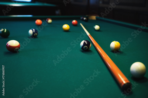 Playing billiard. Billiards balls and cue on green billiards table. Billiard sport concept.