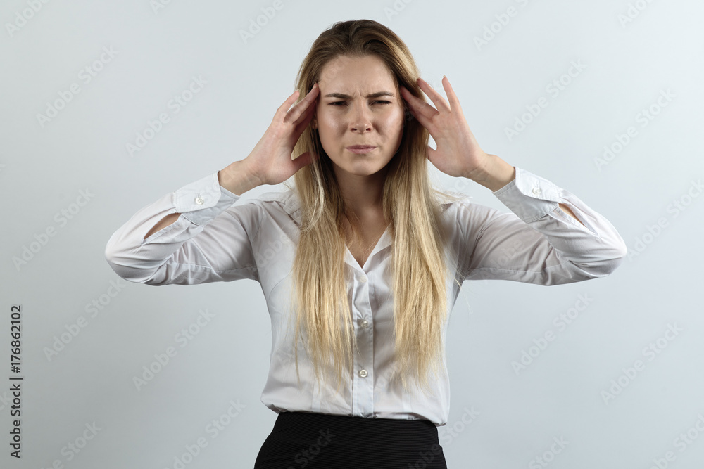 young pretty woman dressed in business style depressed for migraine headache noise. She squeezes his head and frowns