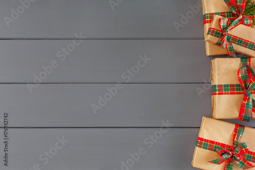 Creative xmas gift boxes in craft paper, ribbons on desk background