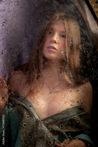 Young woman looking in mirror photo
