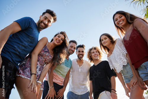 Group of friends standing together outside smiling