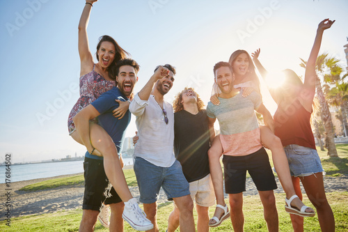 Group of friends having fun outside in sunlight
