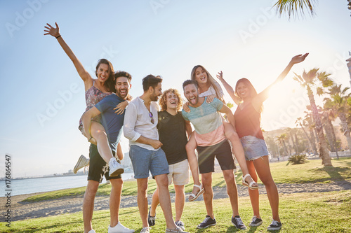 Group of friends having fun together outside in sunlight