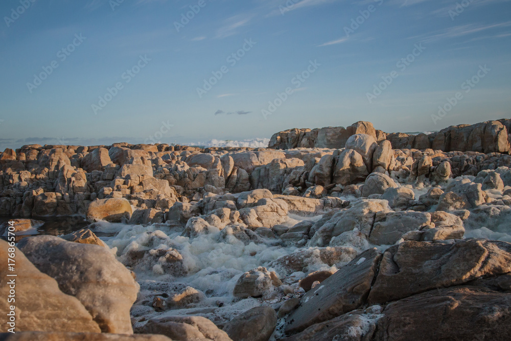 Rough sea with foam over rocks