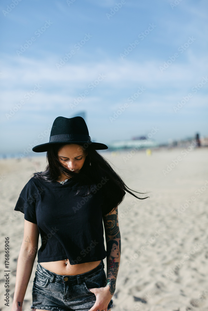 Alternative young woman with tattoos walking on the beach Alternative young woman with tattoos walking on the beach