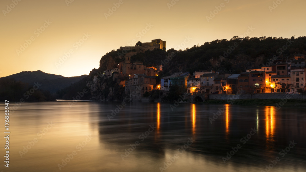 Naklejka premium Vista del pueblo de Miravet (Tarragona), junto al río Ebro en un atardecer dorado