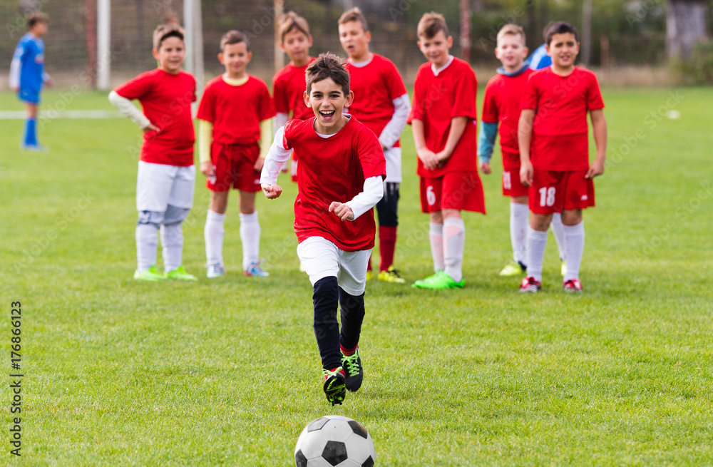 Naklejka premium Kids soccer football - children players match on soccer field