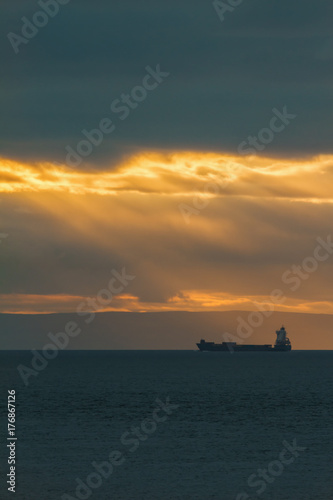 Container Cargo ship in the ocean at sunset sky, silhouette