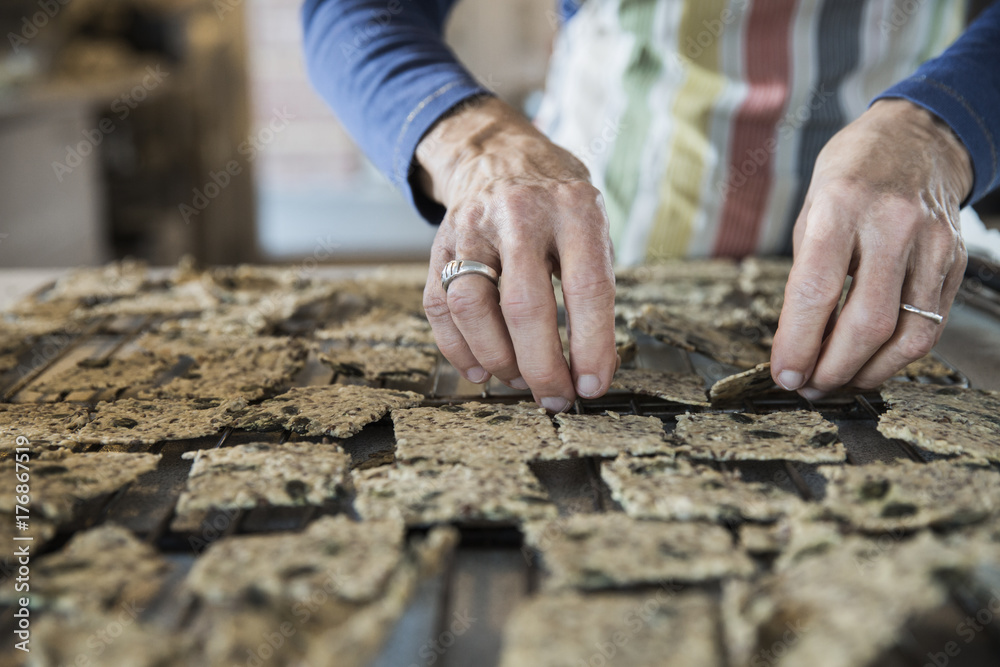 Hands distributing crackers on baking rack
