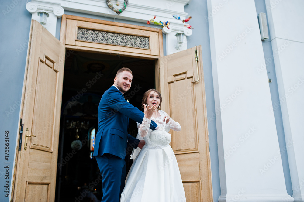 Wedding couple throwing candies after the wedding ceremony outside the church.