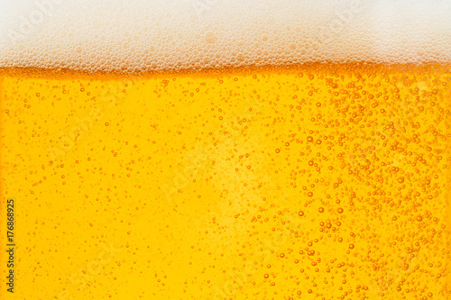Pouring beer with bubble froth in glass for background