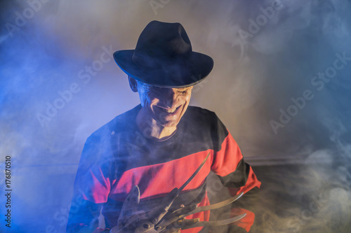 man is a serial killer with a glove sharp knives background for Halloween