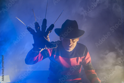 man is a serial killer with a glove sharp knives background for Halloween photo