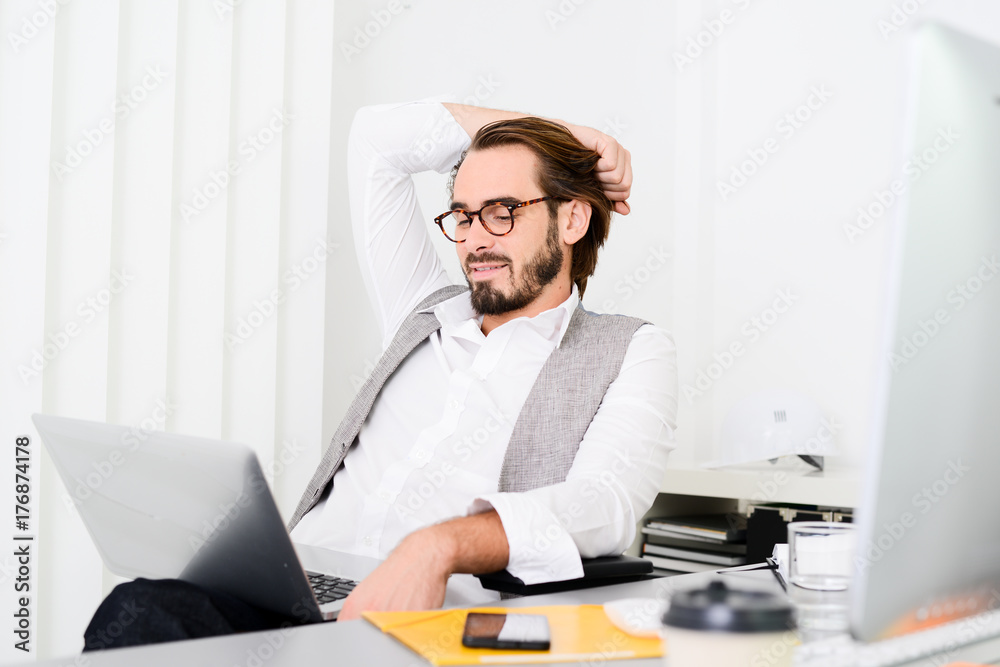 handsome young trendy successful business man in casual wear working in a startup office