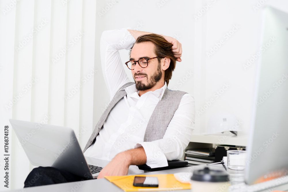 handsome young trendy successful business man in casual wear working in a startup office handsome young trendy successful business man in casual wear working in a startup office