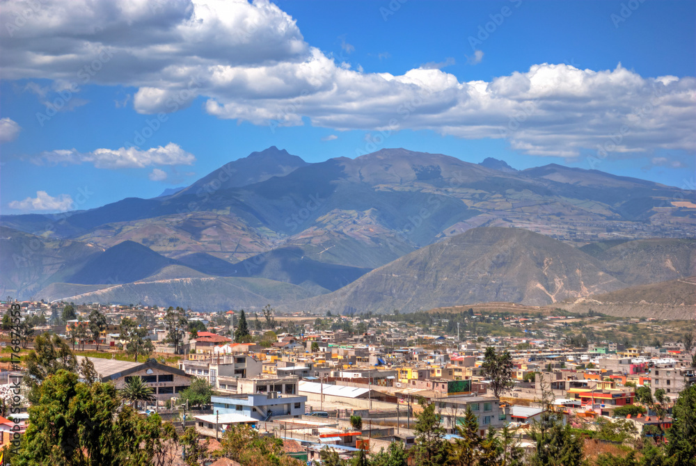 View of the Middle of the World town and the Andes mountains in the background, on a sunny and cloudy summer morning, Ecuador.