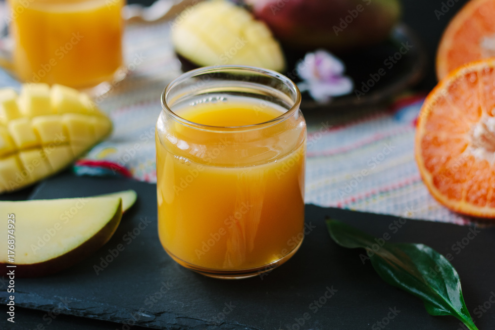 Orange and mango fruit juice over black slate. Orange and mango fruit juice over black slate.