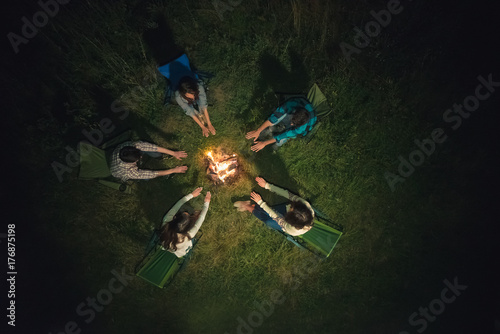 The people warming hands near a bonfire. view from above, evening night time