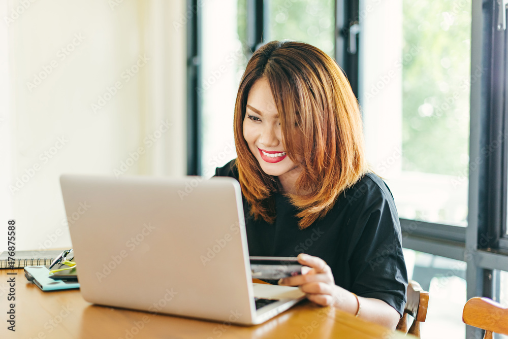 Asian stylish glasses woman designer wear black dress and red lips shopping with credit card on internet in selective focus.. Asian stylish glasses woman designer wear black dress and red lips shopping with credit card on internet in selective focus..