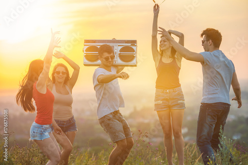 The five people dancing with a boom box on the sunny background