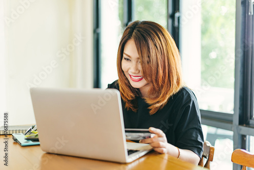 Asian stylish glasses woman designer wear black dress and red lips shopping with credit card on internet in selective focus.. Free Download Asian stylish glasses woman designer wear black dress and red lips shopping with credit card on internet in selective focus.. - GFXLoad