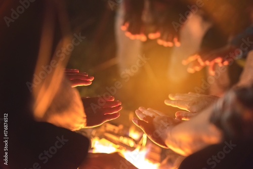 The people warming hands near a bonfire. evening night time