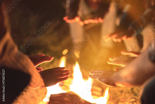 The people warming hands near a bonfire. evening night time