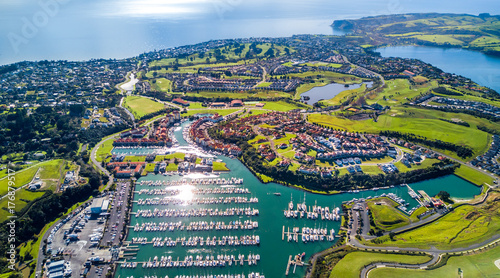 Aerial view on residential suburbs surrounded by sunny ocean harbour. Whangaparoa peninsula, Auckland, New Zealand