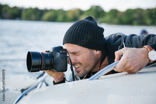 Portrait of Male Photographer Shooting With Digital DSLR Camera on Boat photo