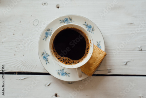 White cup of coffee on the white wooden table