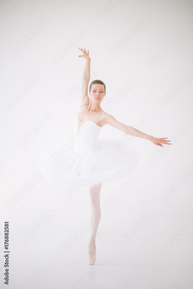 Beautiful ballerina in white costume dancing in the white clean space Beautiful ballerina in white costume dancing in the white clean space