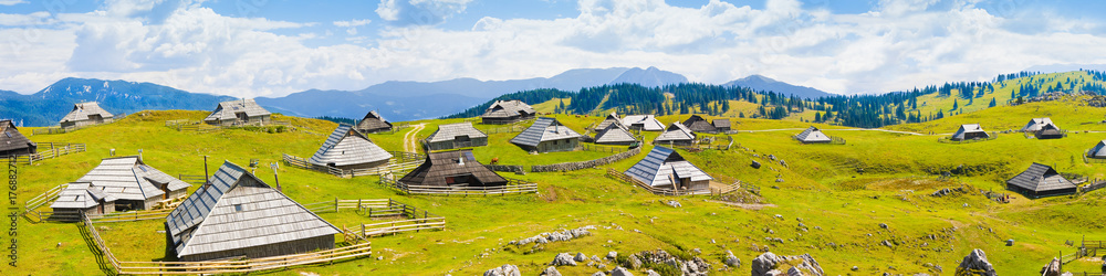 "Velika Planina", which in Slovenian means "great plateau" is one of the most important Slovenian highlands with a particular architecture of wooden huts and barns - obrazy, fototapety, plakaty 